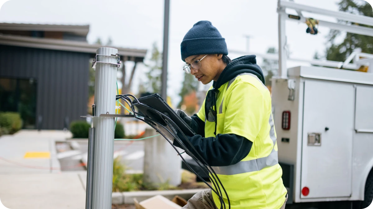 Worker in hi-vis jacket fixing cables